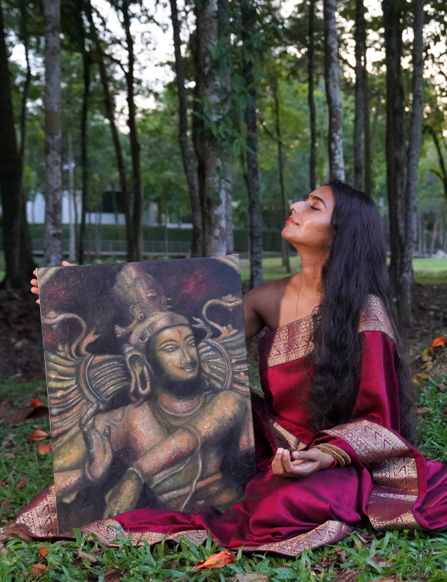 Shantrika seated in a grove holding an original painting of Shiva